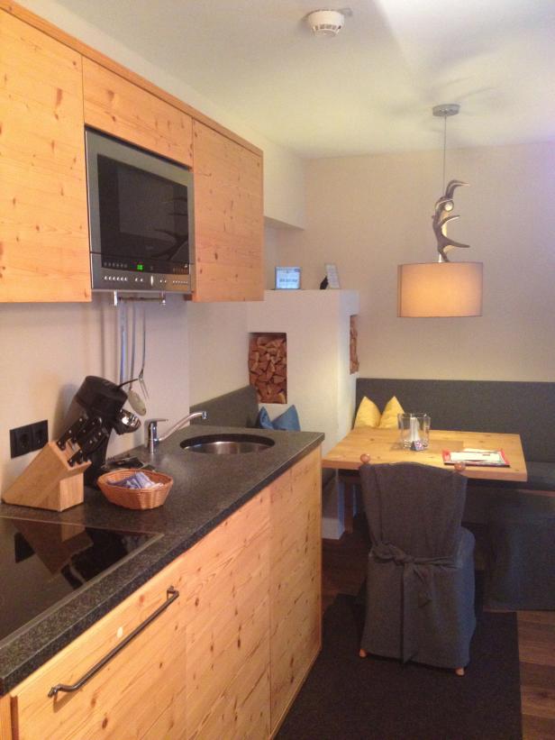 Eine kleine Küche mit Holzeinrichtung und einem Esstisch mit Eckbank.