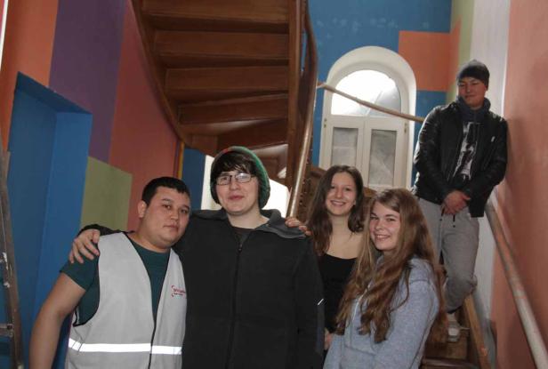 Eine Gruppe junger Leute steht auf einer bunten Treppe.