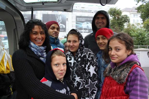 Eine Gruppe von Menschen steht zusammen im Laderaum eines Transporters.