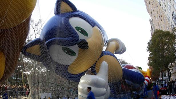 Ein riesiger Sonic the Hedgehog-Ballon bei einer Parade in einer Stadt.
