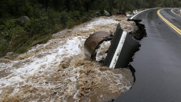 Hochwasser hat einen Teil einer asphaltierten Straße unterspült.
