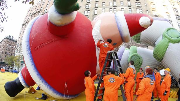 Helfer bereiten eine riesige Santa-Claus-Figur für eine Parade vor.