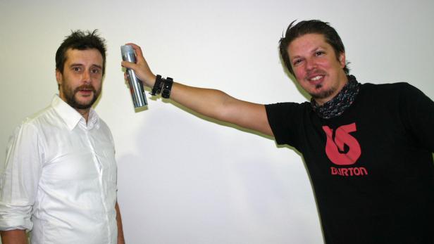 Zwei Männer posieren, einer hält eine Spraydose in der Hand.