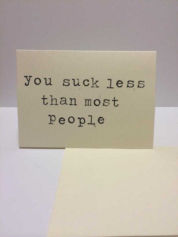 Eine Karte mit der Aufschrift „You suck less than most people“.