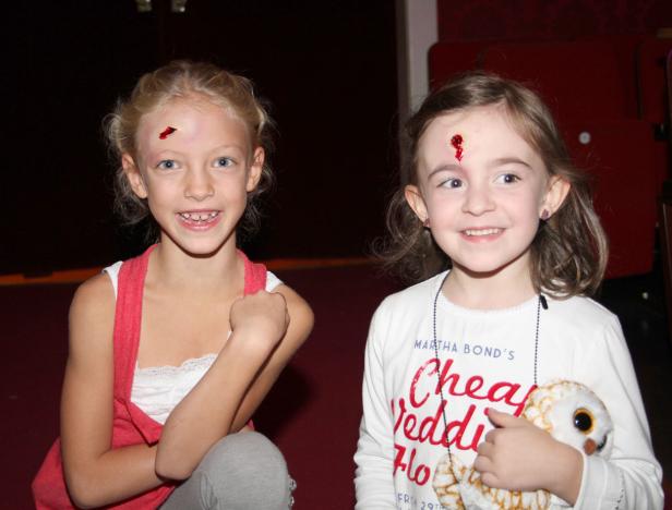 Zwei Mädchen mit Halloween-Make-up lächeln in die Kamera.