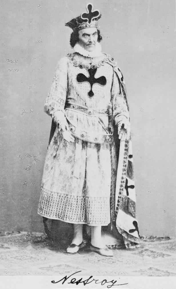 Der Schauspieler Johann Nestroy in einer Theaterrolle mit Krone und Umhang.
