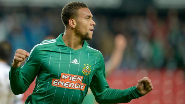 Ein Fußballspieler in einem grünen Trikot mit dem Logo von Rapid Wien jubelt.