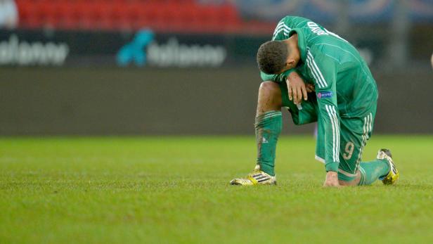 Ein Fußballspieler kniet enttäuscht auf dem Rasen.