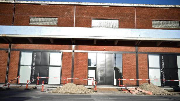 Die Fassade der Faurschou Foundation mit Baustellenabsperrungen und Erdhaufen davor.