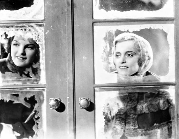 Zwei Frauen blicken durch ein vereistes Fenster.