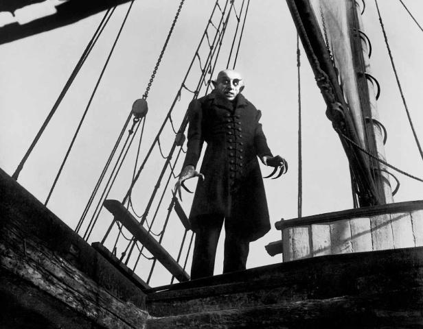 Nosferatu steht mit langen, gebogenen Fingernägeln auf einem Schiff.
