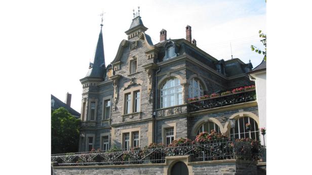 Ein großes, verziertes Gebäude mit einem Turm und blühenden Blumenkästen.