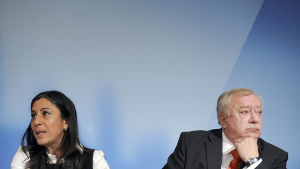 Eine Frau spricht, während ein Mann mit der Hand am Kinn nachdenklich aussieht.