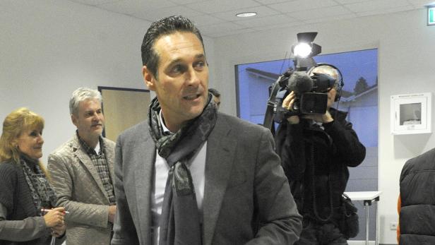 Ein Mann mit Anzug und Schal wird von einem Kamerateam gefilmt.
