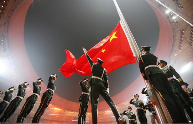Soldaten hissen die chinesische Nationalflagge in einem Stadion.
