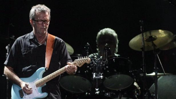 Eric Clapton spielt Gitarre bei einem Konzert.