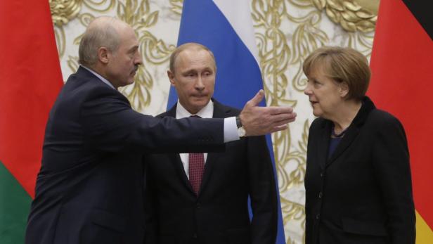 Alexander Lukaschenko, Wladimir Putin und Angela Merkel bei einem Treffen.
