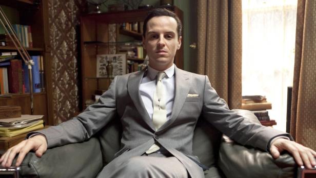 Andrew Scott als Jim Moriarty sitzt in einem Sessel.