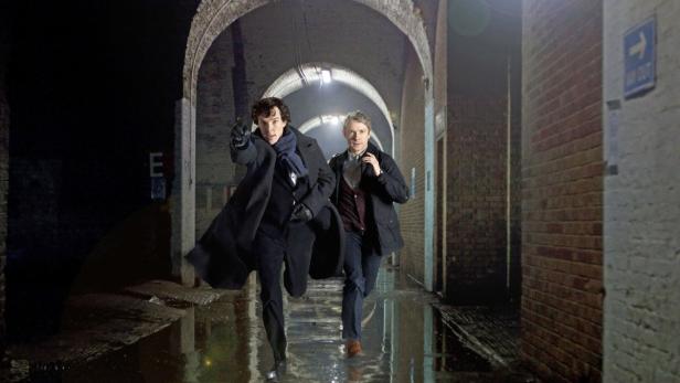Sherlock Holmes und Dr. Watson rennen durch einen dunklen Tunnel.