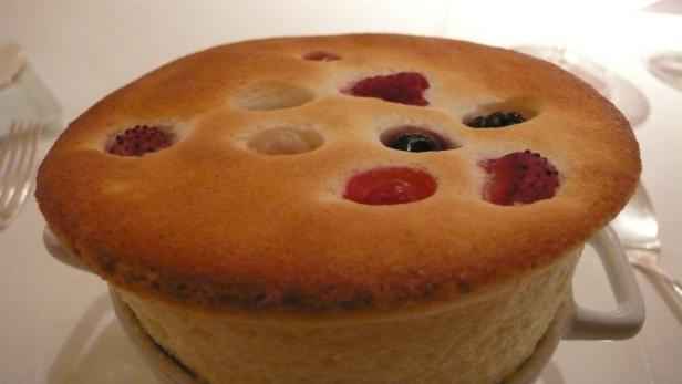 Ein Soufflé mit verschiedenen Beeren in einer weißen Tasse.