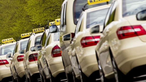 Mehrere Taxis stehen in einer Reihe geparkt.