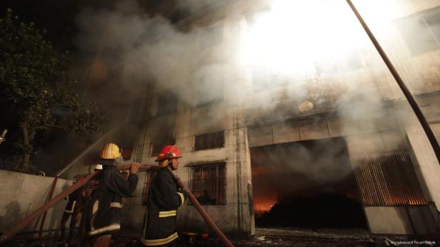 Feuerwehrleute bekämpfen einen Brand in einem Fabrikgebäude.