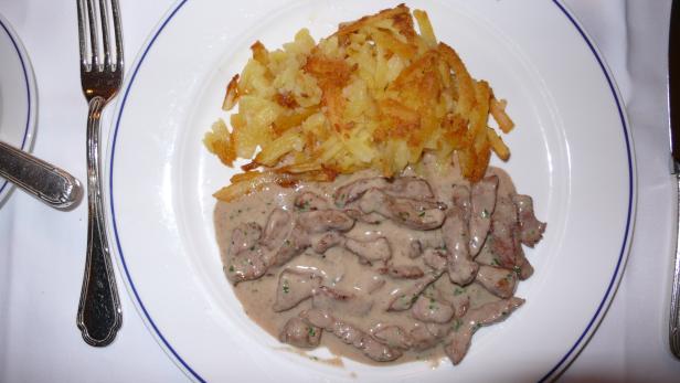 Zürcher Geschnetzeltes mit Rösti auf einem Teller angerichtet.