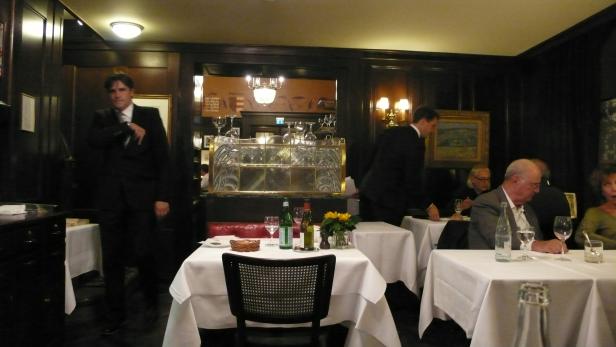 Ein Kellner bedient Gäste in einem eleganten Restaurant.