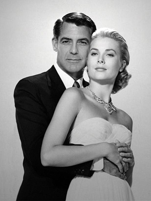 Cary Grant umarmt Grace Kelly, die ein trägerloses Kleid und eine Halskette trägt.