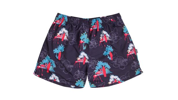 Badeshorts mit einem Muster aus Flamingos, Palmen, Hibiskusblüten und Surfbrettern.