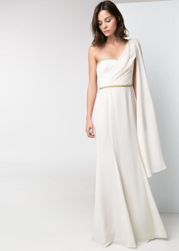 Eine Frau trägt ein elegantes, weißes, schulterfreies Kleid mit goldenem Gürtel.