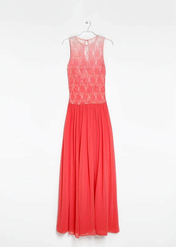 Ein lachsfarbenes, ärmelloses Abendkleid hängt an einem Kleiderbügel vor einem weißen Hintergrund.