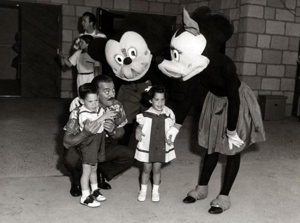 Walt Disney posiert mit Kindern und Mickey- und Minnie-Maus-Darstellern.