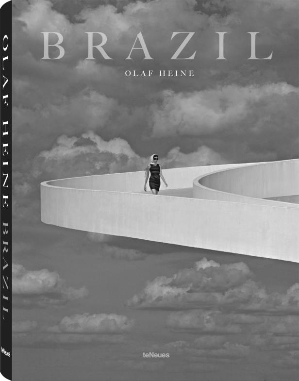 Das Cover des Buches „Brazil“ von Olaf Heine zeigt eine Frau auf einem geschwungenen, weißen Bauwerk vor einer Wolkenlandschaft.