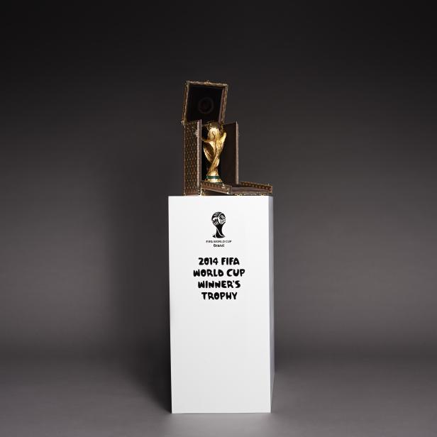 Die FIFA Fussball-Weltmeisterschaft Trophäe in einem Louis Vuitton Koffer auf einem Podest.