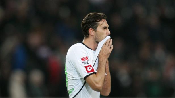 Ein Fußballspieler wischt sich mit einem Trikot den Schweiß ab.