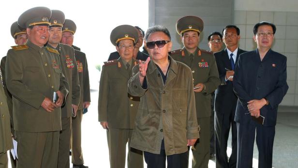 Kim Jong-il mit Sonnenbrille und einer Gruppe von Militärangehörigen.