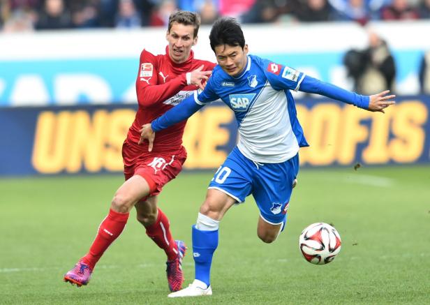 Zwei Fußballspieler kämpfen um den Ball während eines Spiels.