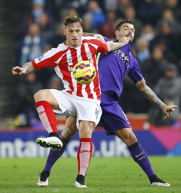 Zwei Fußballspieler kämpfen um den Ball während eines Spiels.