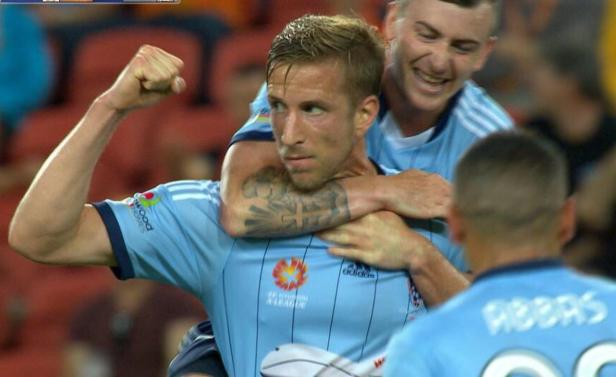 Ein Fußballspieler wird von seinen Teamkollegen nach einem Torerfolg umarmt.