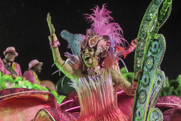 Eine Frau in einem farbenprächtigen Kostüm nimmt an einer Karnevalsparade teil.