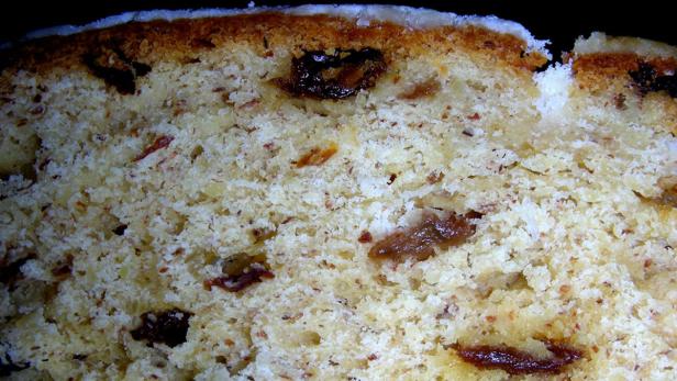 Ein angeschnittener Früchtekuchen mit Zuckerguss und Rosinen.