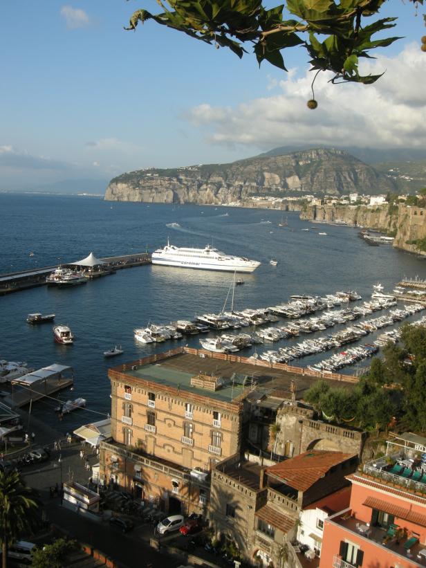 Blick auf den Hafen von Sorrent mit zahlreichen Booten und einem großen Fährschiff.