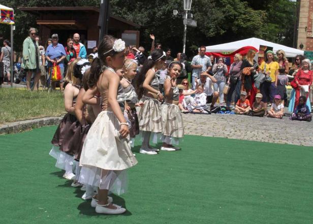 Eine Gruppe junger Mädchen in Kostümen tritt vor einem Publikum auf.