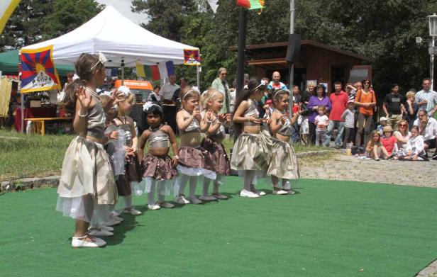Eine Gruppe junger Mädchen in Kostümen steht auf einer Bühne vor Publikum.
