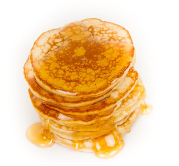 Ein Stapel Pfannkuchen mit goldgelbem Sirup übergossen.