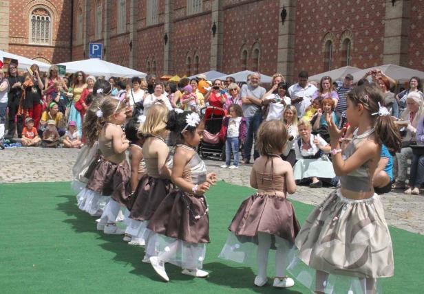 Eine Gruppe junger Mädchen in Kostümen tritt vor Publikum auf.
