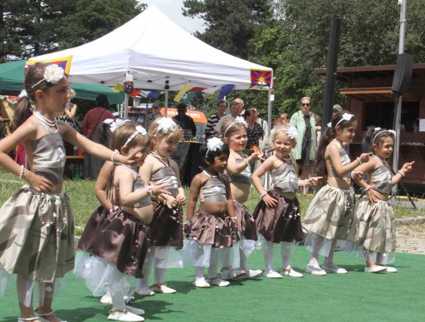 Eine Gruppe junger Mädchen in Kostümen tanzt im Freien.