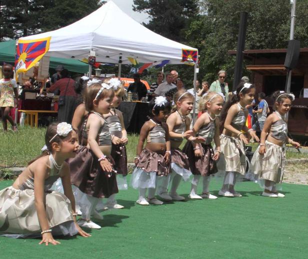 Eine Gruppe junger Mädchen in Kostümen steht auf einer Bühne.