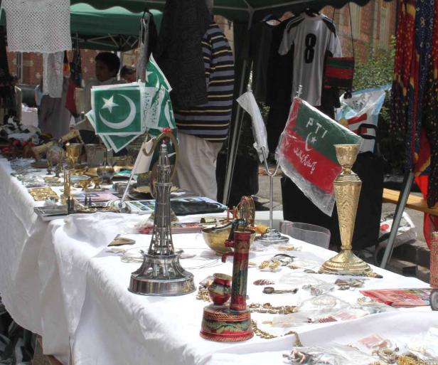 Ein Verkaufsstand mit pakistanischen Flaggen und Souvenirs auf einem Markt.